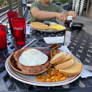 a man sitting at a table with breakfast