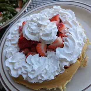 a plate of strawberries and whipped cream