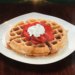 a waffle with strawberries and whipped cream