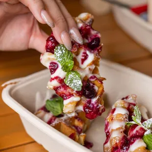 a person picking up a pastry