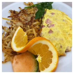 an omelet, hash browns, and orange slices