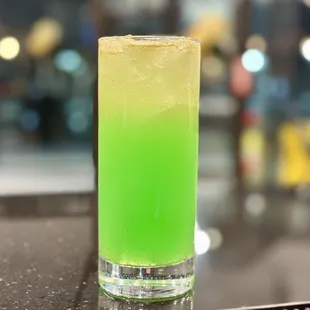 a close up of a glass with a green drink in it