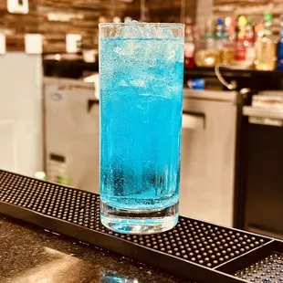 a blue drink on a bar