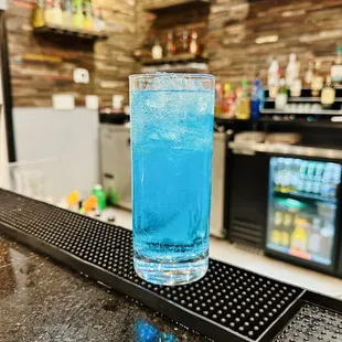 a blue drink on a bar