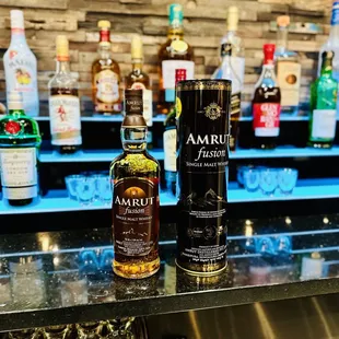 a bottle of amrut whisky and glasses