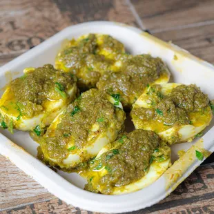 a plate of eggs with pesto sauce