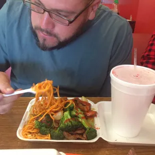 My husband about to enjoy his chow main and broccoli beef , mushroom chicken