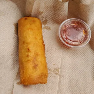 a fried egg roll and a cup of ketchup
