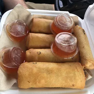 Two pork and two chicken egg rolls with sauce