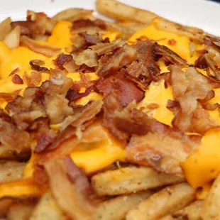 a plate of fries with cheese and bacon