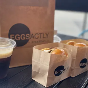 a cup of coffee and a bag of doughnuts