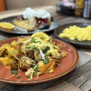 Foreground is Baja Chicken Hash Stack (split onto 2 plates). Fun fact... the OJ here is fresh squeezed.