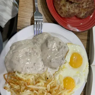 Half biscuits and gravy with eggs and hash browns with a side of Sausage.
