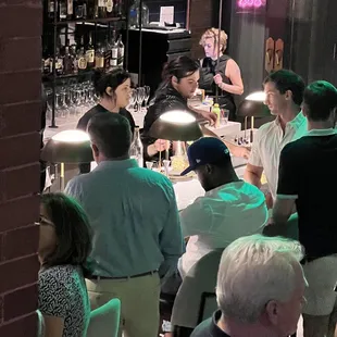 Bartenders helping some, telling select customers to get lost and wait 1 hour for one cocktail