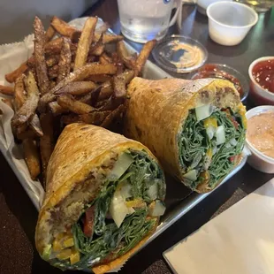 Veggie wrap - hummus, falafel, cheddar, bell pepper, tomato, cucumber, spinach, tzatziki in a honey, wheat wrap