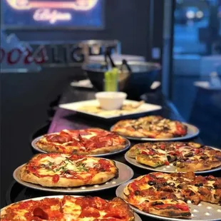 a row of pizzas on a table