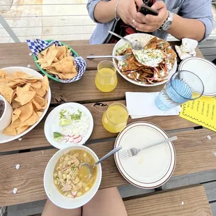  a woman sitting at a picnic table with food and drinks