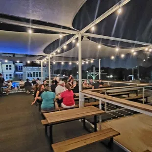  people sitting at tables under a canopy