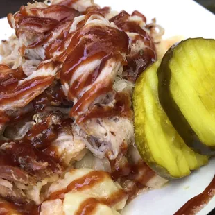 a plate of pulled pork and a pickle