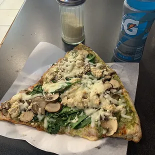 a slice of pizza with mushrooms and spinach