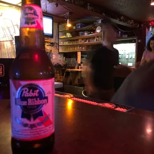 a bottle of beer on a bar counter
