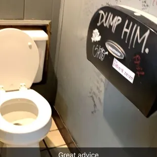 a toilet with graffiti on the walls