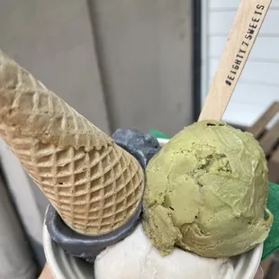 a hand holding a bowl of ice cream