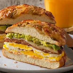 ows a sandwich on a plate with a glass of orange juice