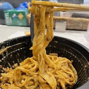 a bowl of noodles with chopsticks