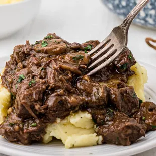 a plate of beef and mashed potatoes