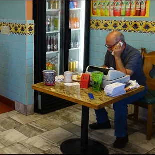 You check out the menu, but you place your order to this gentleman, who also takes your money.