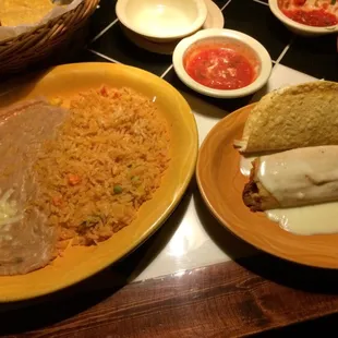 A tamale, taco, and side of rice and beans.