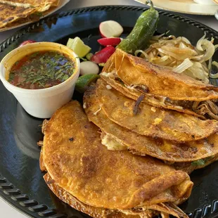 Birria tacos with radish, grilled onion, Jalapeños