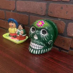 a mexican sugar skull and a mexican figurine
