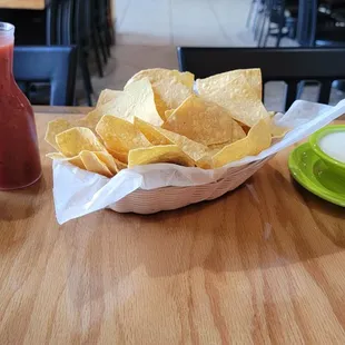 a bowl of chips and a drink