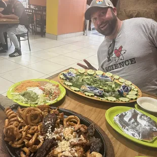 a man sitting at a table with plates of food