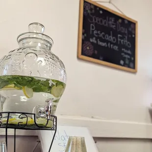 Water Station with lemon and mint.  "Special of the Day" announcement hangs on wall.