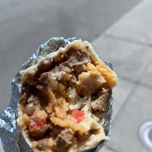  a hand holding a burrito