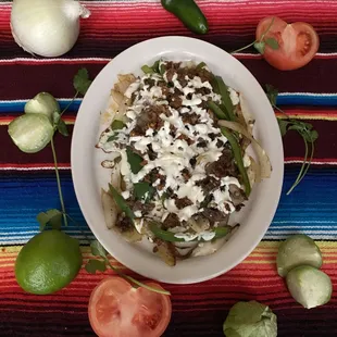Alambres are a fajita-style dish with asada, chorizo, bacon, onion, green pepper and melted cheese. Served with corn tortillas