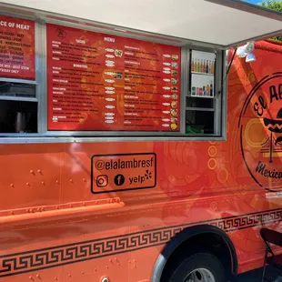 an orange food truck parked in a parking lot