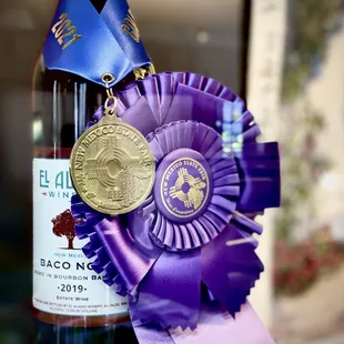 a bottle of wine with a rose ribbon