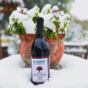 a bottle of red wine in the snow