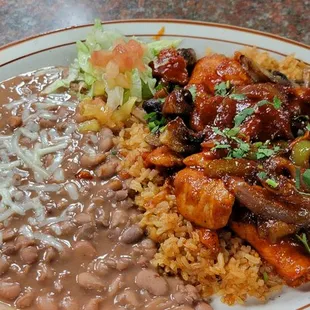 a plate of beans, rice, and meat