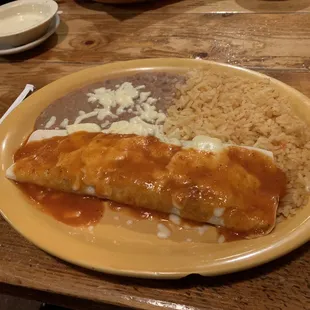 Beef burrito with rice and beans.