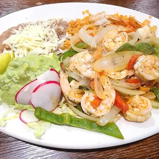 Fajitas de Camaron - shrimp cooked with bell peppers, onions, and tomatoes. Served with rice, beans, guacamole, and tortillas.