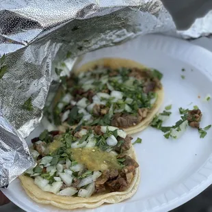 two tacos on a paper plate