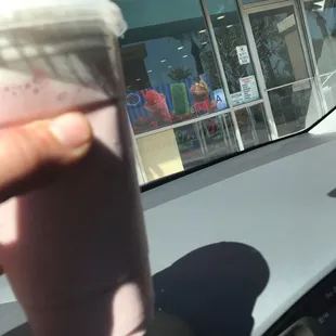 a hand holding a cup of milkshake