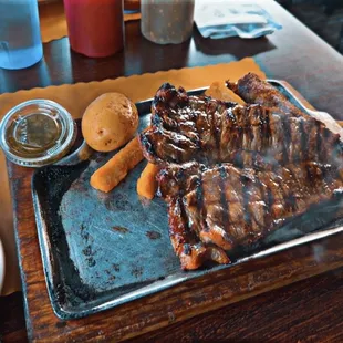 a plate of ribs and potatoes