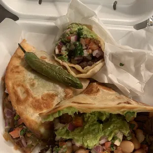 two burritos in a styrofoam container