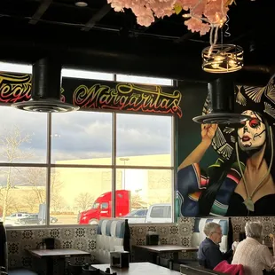 a restaurant with a mural of a woman holding a tray